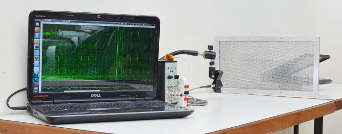 microphone measuring a laptop through a mesh ventilation panel